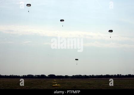 Ungarischen, Bulgarischen und US Special Operations Forces Parachute auf einem Flugplatz 21. Juli in Szolnok, Ungarn während einer kombinierten Betrieb als Teil der Übung Black Swan. Special Operations Forces aus den USA, Ungarn und Rumänien durchgeführt Statische kombinierte Online- und Höhenlage - geringe Öffnung airborne Operations 21. Juli 2017 während der Übung Black Swan in Ungarn. Black Swan war ein Ungarisch-led-Special Operations Forces Übung vom 26. Juni bis 22. Juli 2017 über Standorte in Bulgarien, Ungarn und Rumänien und enthalten Teilnehmer aus über acht Ländern. Fallschirmjäger aus den USA Stockfoto