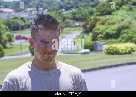 Us Air Force Airman 1st Class Luis Bernal, 18 Sicherheitskräfte Squadron defender, versucht normalerweise, nachdem Sie mit OC Spray während Taser und OC Spray training Juli 20, 2017 gesprüht, um zu atmen, bei Kadena Air Base, Japan. Die OC-spray bewirkt eine vorübergehende Blindheit, die in der Schwebe. Stockfoto