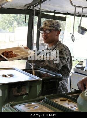 U.S. Army Reserve SPC. Raphaelle Tangco, einem kulinarischen Fachmann mit der 883Rd Quartermaster Firma, serviert Mahlzeiten während der zwei Wochen 2017 Quartermaster Flüssiglogistik Übung in Joint Base Lewis McChord, Jan. 14 bis 27, 2017. QLLEX ermöglicht die US Army Reserve Einheiten, um ihr Können unter Beweis zu stellen und der realen Welt Kraftstoff und Wasser unterstützt, während der Ausbildung an der taktischen, operativen und strategischen Ebene. Stockfoto