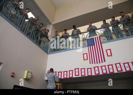 Ein Mitglied der 66th Sicherheitskräfte Squadron hängt ein service Banner am 18. Juli im Atrium des Gebäudes 1725 als Teil der Tradition der Squadron für Truppen bereitstellen, während SFS Flieger auf. Mitglieder der Staffel vor kurzem auf eine übersee Bereitstellung. Stockfoto