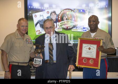 Von links, Kommandant der Marine Corps Gen. Robert B. Neller, Todd Dooley, Neffe des US Marine Corps Staff Sgt. Tommy Loughran und Sgt. Maj. des Marine Corps Ronald L. Grün posieren für ein Foto während der US Marine Corps Sports Hall of Fame Induktion Zeremonie am nationalen Museum der Marine Corps, Dreieck, Virginia, 12. Juli 2017. Die Veranstaltung wurde moderiert von US Marine Corps Generalleutnant Mark A. Brilakis, stellvertretender Kommandant, Manpower und finden, dass im Preis inbegriffen ein Abendessen, eine Videopräsentation und Trophy Präsentationen zu den Familien der eingezogenen. Stockfoto