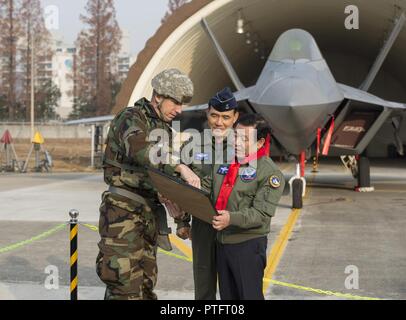 Kadena Air Base, Japan, 18 Wing Commander, Brig. Gen. Fall A. Cunningham präsentiert ein Foto zum Bürgermeister von Gwangju, Jang Hyun Yoon, vor der F-22 Raptor, Dez.07, 2017, unter Gwanju Air Base, Republik Korea. Der Bürgermeister war in der Lage, die wichtigsten Führer der Wachsam Ace Übung in Gwangju AB zu sprechen. Stockfoto