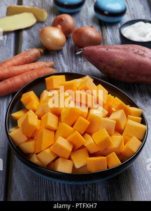 Zutaten für butternut Kürbis Suppe mit Süßkartoffeln und Ingwer, auf Grau rustikaler Hintergrund Stockfoto