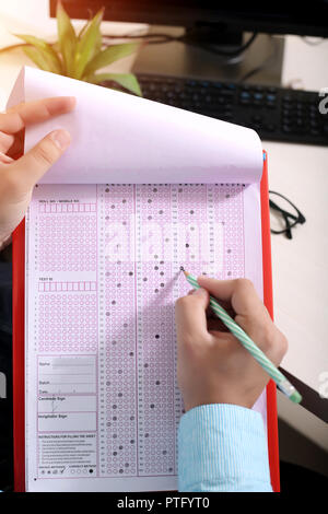 Man füllt OME-Blatt mit Bleistift. Bild der OME-Blatt in der Zwischenablage. Stockfoto