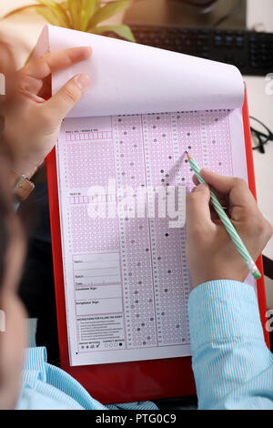 Man füllt Circle auf der OME-Blatt mit Bleistift. Bild der OME-Blatt in der Zwischenablage. Stockfoto