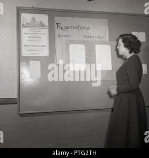 1950er Jahre, junge Dame Student an eine Liste von Namen für Ausflüge nach Amersham und Stratford-upon-Avon auf einem Schild an der Universität von London suchen, mit einer Benachrichtigung über einen Kurs von Shakespeare Erweiterung Vorträge. Stockfoto