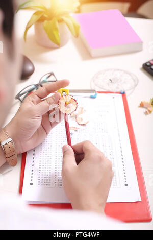 Mann schärfen Bleistift mit Hilfe von Spitzer. Bild der OME-Blatt, Zwischenablage, Gläser, Blumentopf, Kreis Umfang und Gläser. Stockfoto