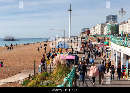 Brighton, England, 07. Oktober 2018. Menschen am langen Kiesstrand in Brighton, die British Airways ich 360 und West Pier auf dem Hintergrund ruiniert, Sel Stockfoto