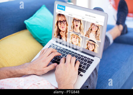 Das zusammengesetzte Bild im unteren Bereich der männlichen Executive mit Laptop beim Sitzen auf dem Sofa Stockfoto