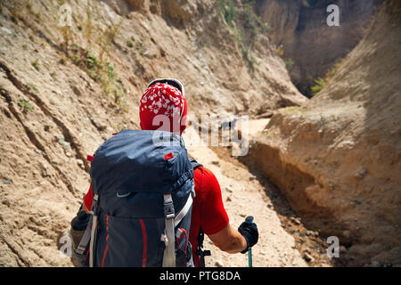 Touristische in Red Hat mit Rucksack in den Schluchten, Rückansicht Stockfoto