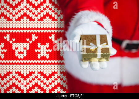 Zusammengesetztes Bild des Weihnachtsmannes halten in der hand eine Geschenk-box Stockfoto