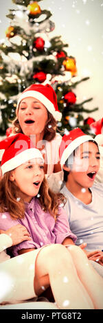 Das zusammengesetzte Bild der erweiterten Familie singen Weihnachtslieder Stockfoto