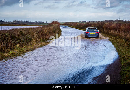 Auto durch überflutete Straße in der Nähe von nunney in Somerset, Großbritannien fahren Am 3. Januar 2014 Stockfoto