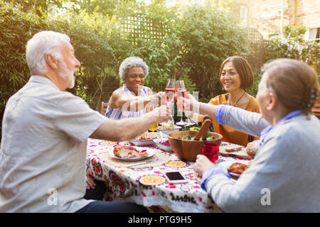 Active Senior Freunde toasten rose Weingläser im Garden Party Stockfoto