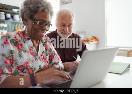 Senior paar Rechnungen bezahlen am Laptop in der Küche Stockfoto