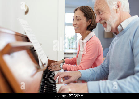 Active Senior paar Klavier spielen Stockfoto