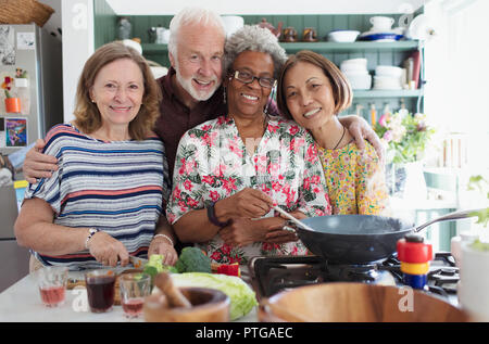 Portrait happy Active Senior Freunde kochen in der Küche Stockfoto