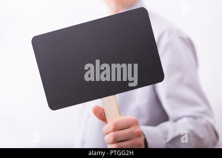 Männliche Hand halten kleine Schwarze Schiefertafel. Stockfoto