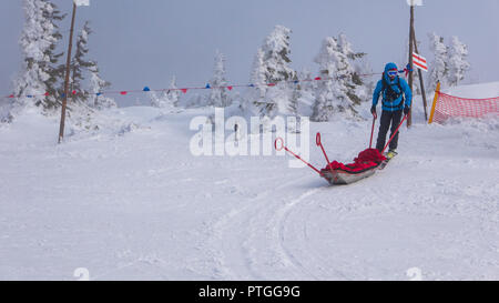 Ski Rescue Team mit Folie Bahre, bringt Hilfe bei schlechten Witterungsverhältnissen Ski zu fahren. Stockfoto