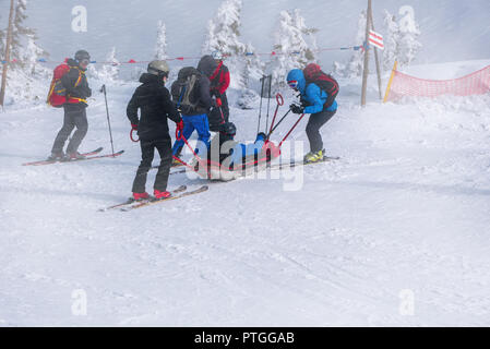 Ski Rescue Team mit Folie Bahre, bringt Hilfe bei schlechten Witterungsverhältnissen Ski zu fahren. Stockfoto