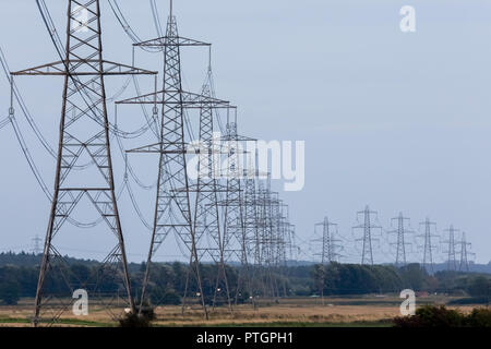 Strommasten oder Sendemasten, Hochspannungsleitungen und Freileitungen über Land als Teil der nationalen Grid-Netzwerk Stromversorgung Stockfoto