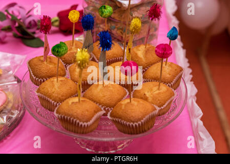 Essen, Backen und Urlaub Konzept - kleine Kuchen oder Muffins mit halloween party Dekorationen und Bonbons an der Platte. Stockfoto