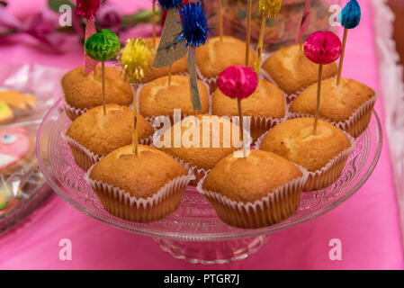 Essen, Backen und Urlaub Konzept - kleine Kuchen oder Muffins mit halloween party Dekorationen und Bonbons an der Platte. Stockfoto