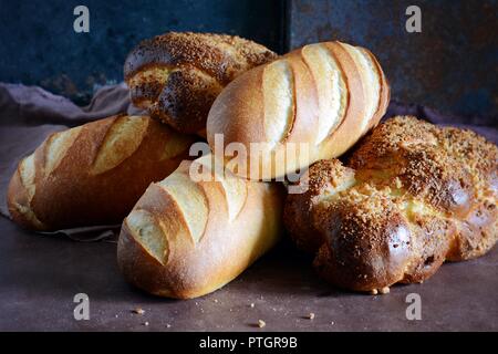 Leckeren frisch gebackenes Brot auf Holz- Hintergrund. Bäckerei Sortiment mit Brot Brote, Brötchen, Brötchen. Verschiedene Arten von Brot Stockfoto