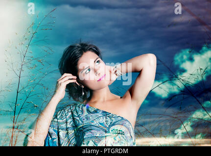 Porträt der schönen Frau, die auf dem Hintergrund des blauen Himmels. Feder, Portrait. Stockfoto