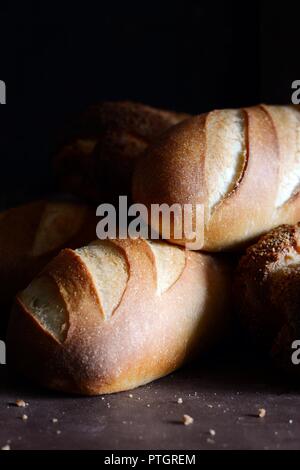 Leckeren frisch gebackenes Brot auf Holz- Hintergrund. Bäckerei Sortiment mit Brot Brote, Brötchen, Brötchen. Verschiedene Arten von Brot Stockfoto