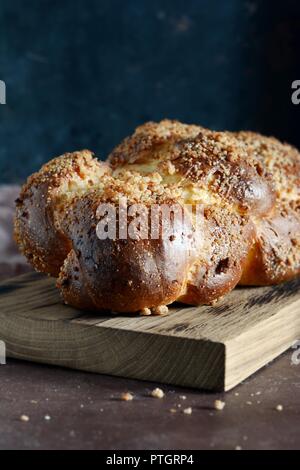 Challah oder Hala ist eine traditionelle jüdische Süße frische Sabbat, das Brot Brot, frische Brötchen auf Schneidebrett. Brioche Brot am Frühstückstisch. Die goldenen glaz Stockfoto