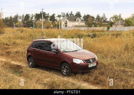 REGION DNIPROPETROWSK, UKRAINE - 18. SEPTEMBER 2016: Volkswagen Polo Burgund Farbe auf der unbefestigten Straße im Herbst Wiese in der Nähe der Landschaft geparkt Stockfoto