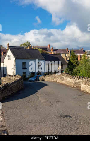 Eine Frau steht an der historischen Brücke über den Fluss Clun, ein packesel Brücke in 1450 erbaut, Clun, Shropshire, Großbritannien Stockfoto