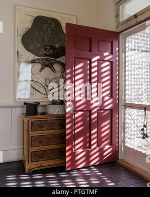 Lattice Bildschirm und Gitter Tür mit Haupteingang rot lackiert. Kleine Brust malte Faux-bois 1870/80 Amerikanische mit Kunstwerken von Terry Winter. Stockfoto