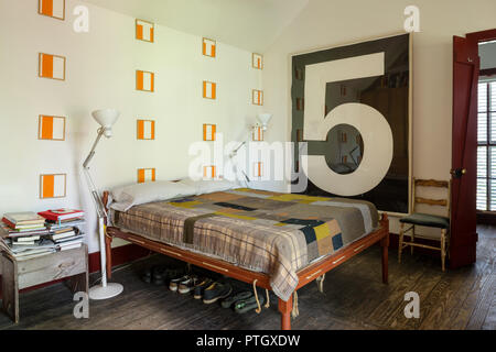 Shaker Bett mit Steppdecke aus Kleidung Stoff-reste mit Drucken von Daniel Buren. Nr. 5 Holzschnitt von Jonathan Borofsky und ein paar weißen Stehlampen durch L Stockfoto