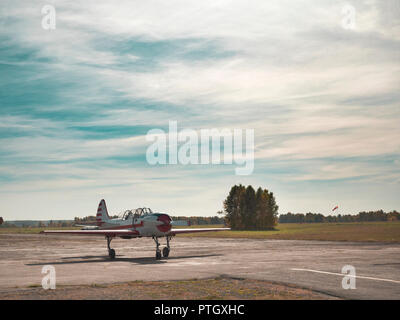 Blick auf Flugzeug auf grasbewachsenen Flugplatz close up; classic Flugzeug rollt zum Start auf Start- und Landebahn; Ausbildung Kunstflug von oldschool Flugzeuge; Freizeitaktivitäten handeln Stockfoto