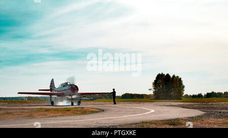 Blick auf Flugzeug auf grasbewachsenen Flugplatz close up; classic Flugzeug rollt zum Start auf Start- und Landebahn; Ausbildung Kunstflug von oldschool Flugzeuge; Freizeitaktivitäten handeln Stockfoto