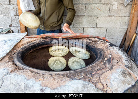 Traditionelle usbekische Fladenbrot backen im Ofen tandyr Stockfoto