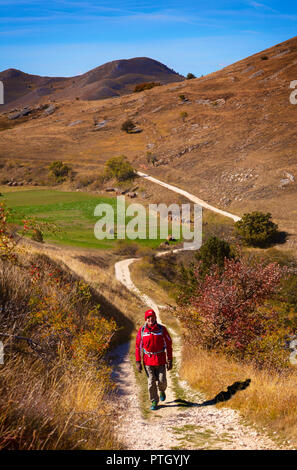 Ein Wanderer auf der Strecke, die auf das 10. Jahrhundert Rocca Calascio, eines Berges eine Festung in der Provinz L'Aquila in den Abruzzen, Italien. Stockfoto