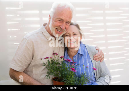 Portrait happy Active Senior Paar mit Blumentöpfen Stockfoto