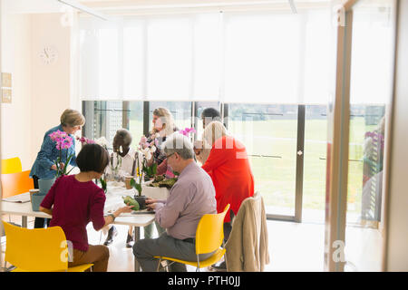 Aktive Senioren genießen blumenarrangierens Klasse Stockfoto