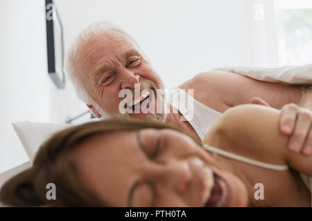 Verspielt, anhänglich senior Paar im Bett Stockfoto