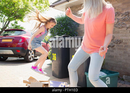 Mutter und Tochter, die Pappe für Recycling ausserhalb des Hauses Stockfoto