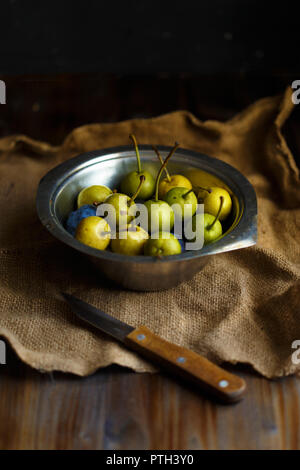 Wilde Birne in eine Schüssel und eine Flasche hausgemachten Pear Wein auf einer hölzernen schließen Hintergrund. Rustikale Konzept. Ernte Platz kopieren Stockfoto