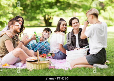Freunde fotografieren im Sommer Picknick im Park Stockfoto