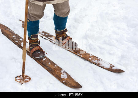 Männliche Füße alten Skifahrer und vintage Skier. Historische Rekonstruktion. Leder Skischuhe und Skier aus Holz Stockfoto