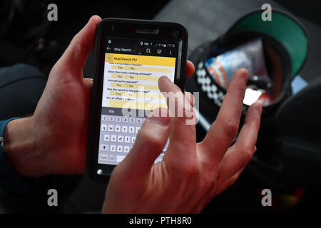 Ein Merseyside Polizei schliesst einen Anschlag und zur Suche auf einem mobilen Gerät bei einem Halt und Suche in der Gegend von Liverpool Bootle Stockfoto