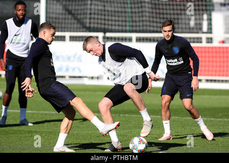 England's Jordan Pickford (Mitte) mit Kieran Trippier (links) und Harry Winks (rechts) während des Trainings im St George's Park, Burton. Stockfoto