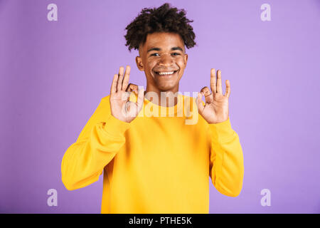 Porträt eines lächelnden jungen afro-amerikanische Mann in Sweatshirt mit Ok gekleidet isoliert Stockfoto