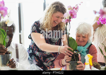 Lächelnde Ausbilder und der älteren Frau, die in der Blume, die die Klasse Stockfoto